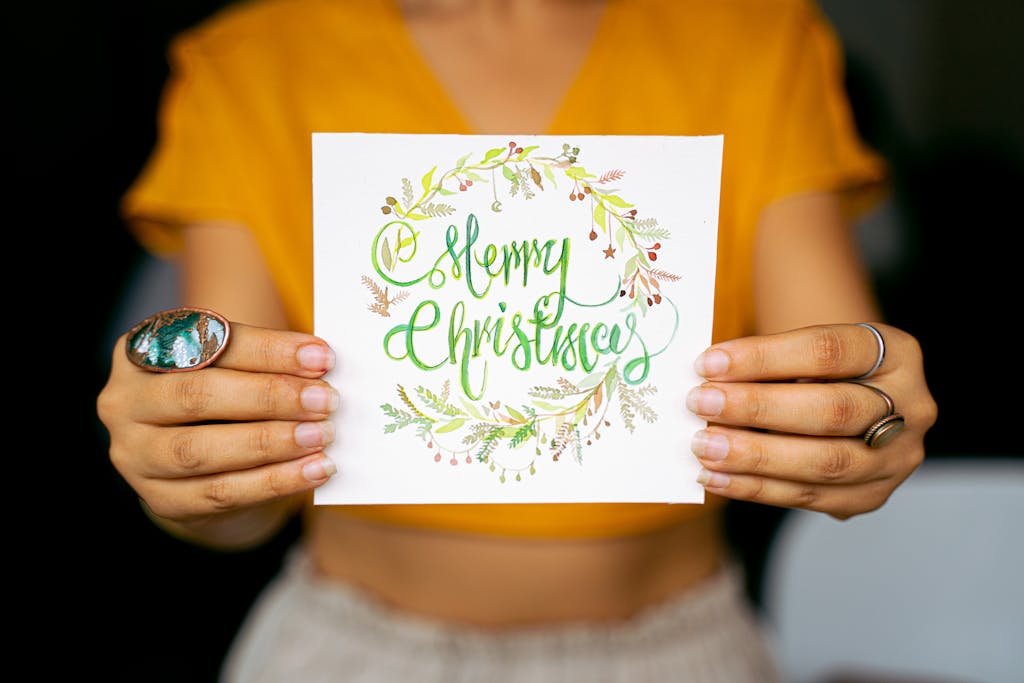 Bright and festive Christmas card held by hands against a blurred background.